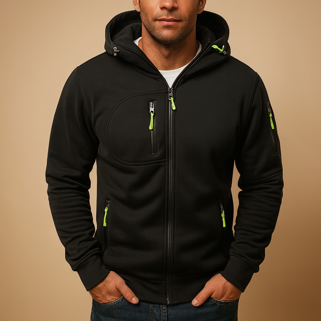 Man wearing a black hoodie with green zippers on a beige background